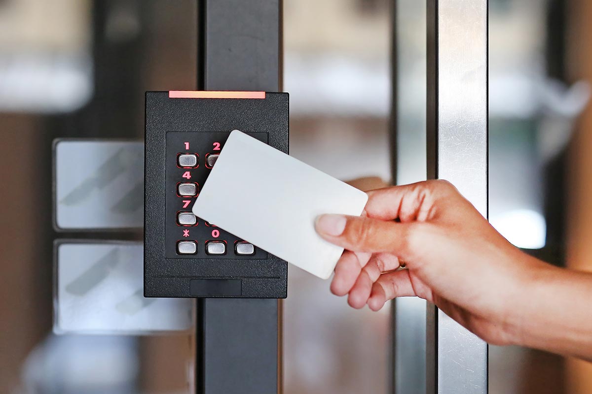 hand-holding-access-card-up-to-security-keypad